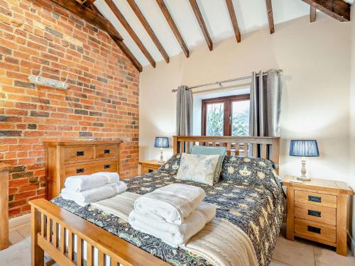 1 dormitorio con cama y pared de ladrillo en 2 Bed in Digby 91059, en Ashby de la Launde