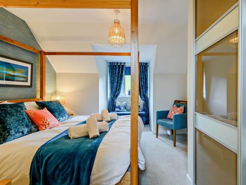 a bedroom with a large bed with blue and red pillows at 3 Bed in Lulworth Cove 91200 in West Lulworth
