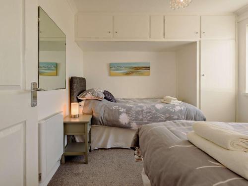 sypialnia z 2 łóżkami i biurkiem z lustrem w obiekcie 2 bed in Gower 91222 w mieście Knelston