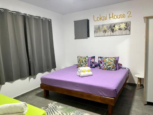 a bedroom with a purple bed in a room at Lokai house in Bora Bora