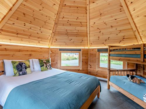 a bedroom with a bed in a wooden cabin at 1 Bed in Biggar 91248 in Libberton