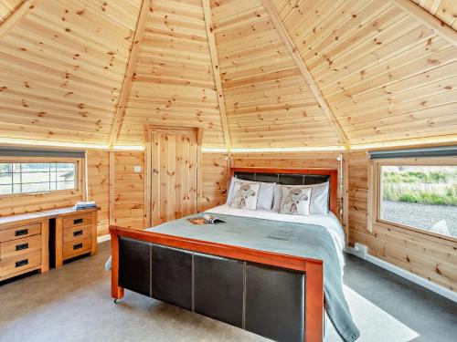 a bedroom with a bed in a wooden cabin at 1 Bed in Biggar 91249 in Libberton