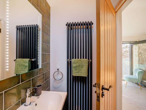 La salle de bains est pourvue d'un lavabo et d'un miroir. dans l'établissement 3 Bed in Dolgellau 90805, à Llanelltyd
