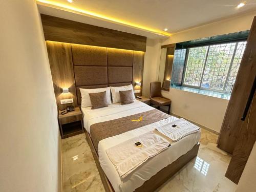 um quarto com uma cama grande e uma janela grande em MIG SUITES em Mumbai