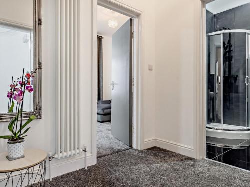 a hallway with a bathroom with a sink and a table at 1 Bed in Allonby 91113 in Allonby