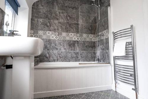 a bathroom with a sink and a bath tub at Stylish 3-Bed Home near Anfield with Parking in Walton on the Hill