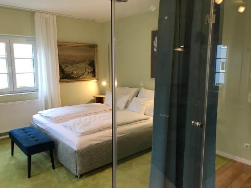 a bedroom with a bed and a glass shower at Lèvres Hotel in Schrobenhausen