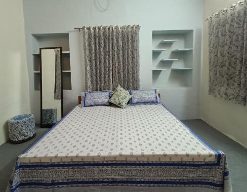 a bedroom with a large bed with blue pillows at Haveli Zorawar in Udaipur