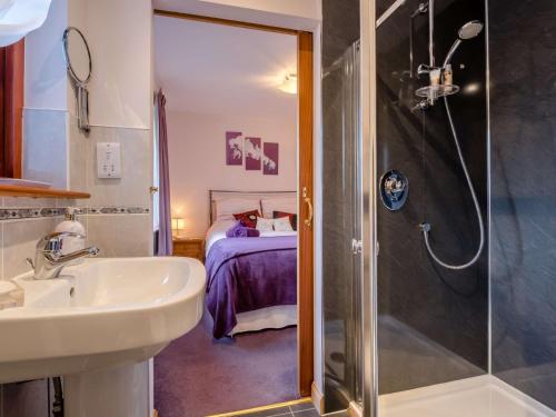 a bathroom with a shower and a sink and a bed at 2 Bed in Culbokie 90813 in Culbokie