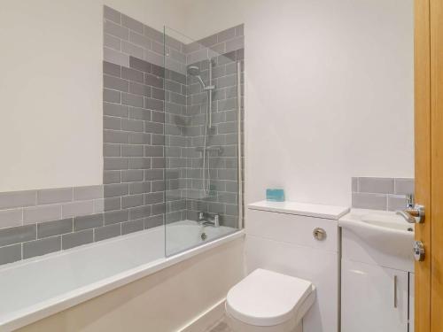 a bathroom with a toilet and a tub and a sink at 2 Bed in Reedham 90882 in Cantley
