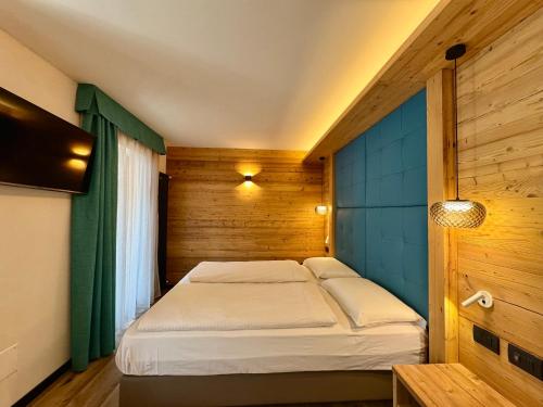 una camera da letto con un letto in una stanza di legno di Dolomiti Luxury Mountain View BIKE FRIENDLY a Canazei
