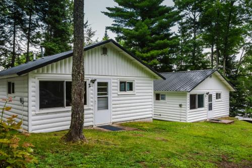 a white cottage with a garage at Elemental Resort in Gwinn