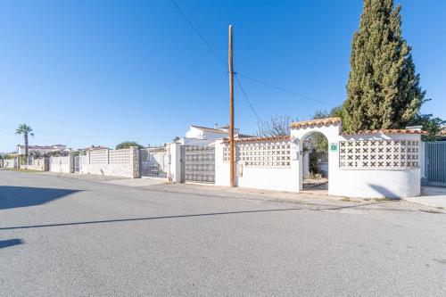 a white fence on the side of a street at Jouvacations Villa Noguera in Empuriabrava