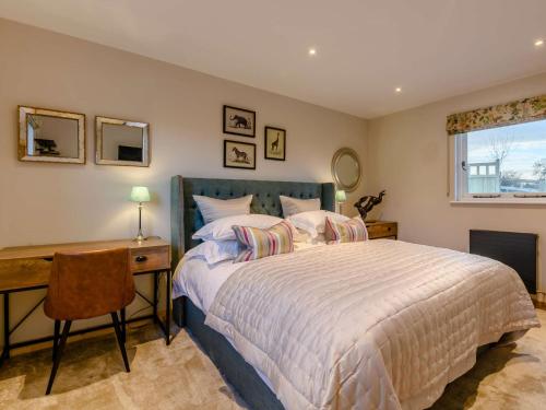 Finghall的住宿－2 Bed in Leyburn 91102，一间卧室配有一张床、一张书桌和一个窗户。