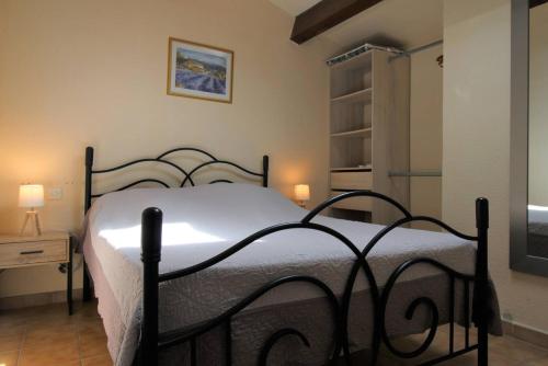 um quarto com uma cama preta e um cobertor branco em GASREM - Golfe de St-Tropez - Mazet dans domaine avec piscine et tennis em Gassin