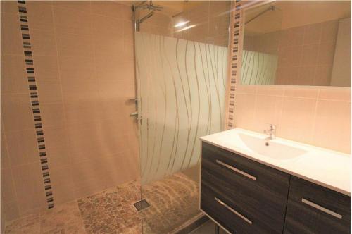 uma casa de banho com um chuveiro, um lavatório e um espelho. em GASREM - Golfe de St-Tropez - Mazet dans domaine avec piscine et tennis em Gassin