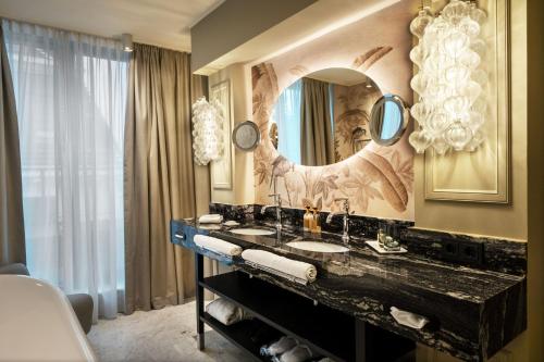 a bathroom with two sinks and a large mirror at Hotel Topazz & Lamée in Vienna
