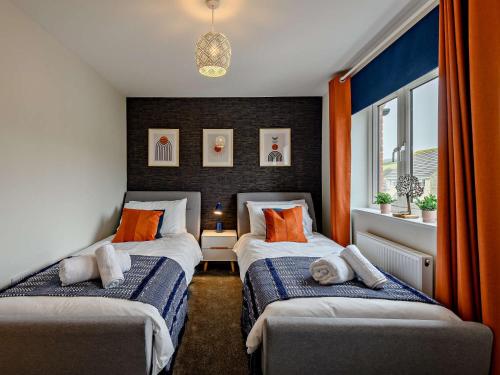 two beds in a room with orange and blue at 2 Bed in Lulworth Cove 91197 in West Lulworth