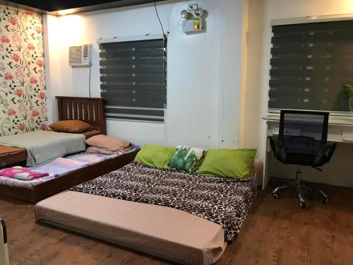 Zimmer mit 2 Betten, einem TV und einem Schreibtisch in der Unterkunft Campayapa in Botolan