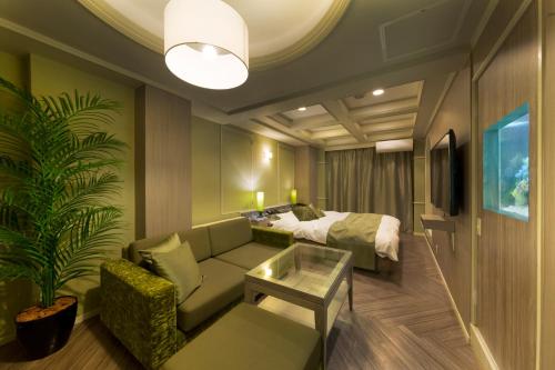 a hotel room with a bed and a couch and a table at Hotel Lotus Modern sakai -Adult Only in Mimiharachō