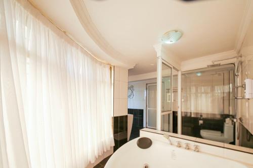 a bathroom with a tub and a large window at Eldon Suites & Apartments in Nairobi