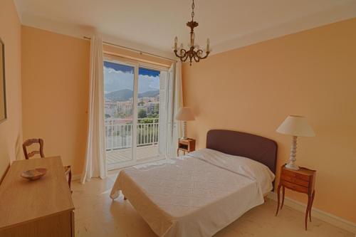 une chambre avec un lit et une grande fenêtre dans l'établissement Appartement centre ville Les Pins Ajaccio, à Ajaccio