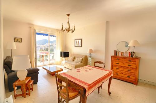 un salon avec une table et un canapé dans l'établissement Appartement centre ville Les Pins Ajaccio, à Ajaccio