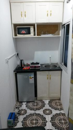 a small kitchen with a sink and a counter at LMD Apartments in Kololi