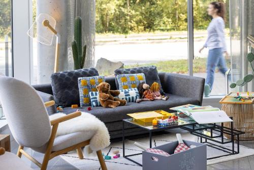 a living room with a couch with stuffed animals on it at Best Western Plus Hôtel Isidore in Saint-Jacques-de-la-Lande