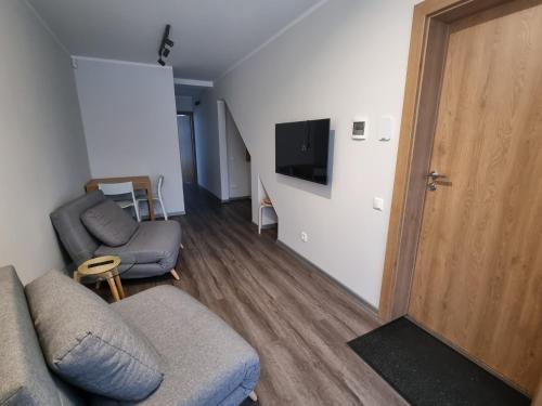 a living room with a couch and a tv and a door at J55 Apartments in Riga