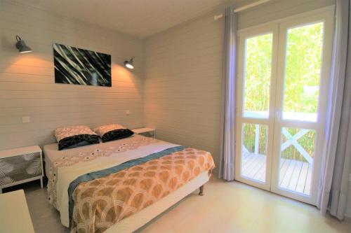 a bedroom with a bed and a sliding glass door at GASMED29 - Golfe de St-Tropez - Chalet californien dans domaine privé in Gassin