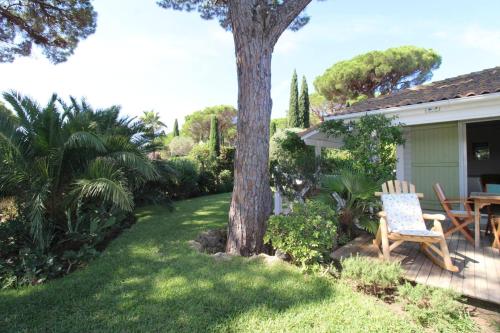 a yard with a tree and a table and chairs at GASMED29 - Golfe de St-Tropez - Chalet californien dans domaine privé in Gassin