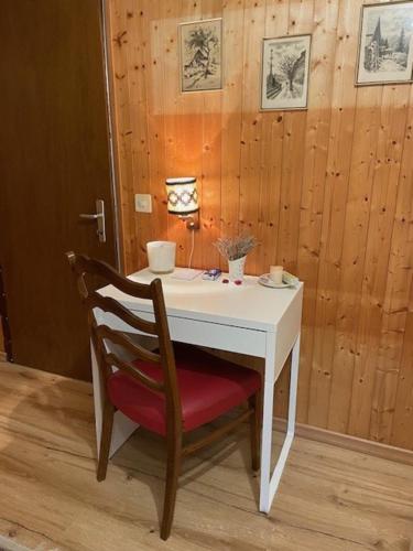 a white table with a red chair and a white table and a table at Sansoucis in Tegna