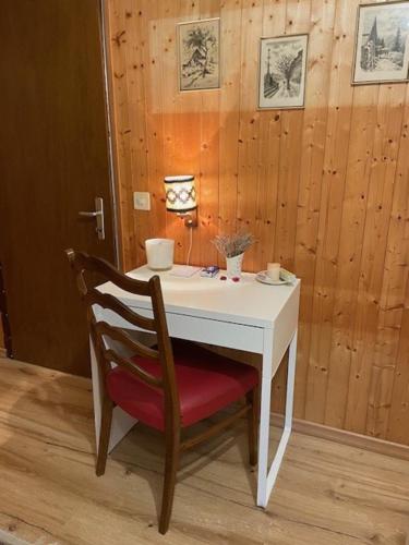 une table blanche avec une chaise rouge et une table blanche dans l'établissement Sansoucis, à Tegna