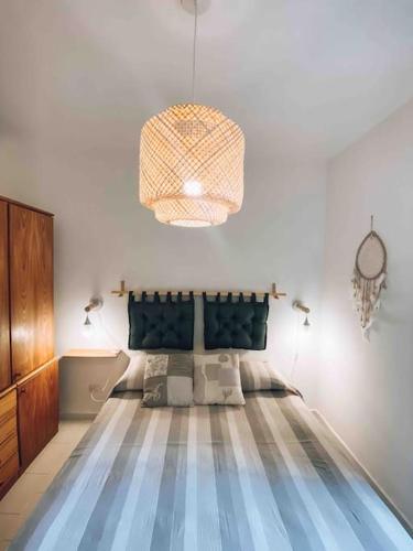 a bedroom with a bed and a chandelier at n4 RELAXING SEAVIEW APARTMENT in Stintino