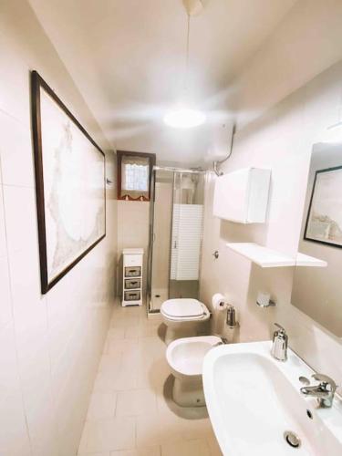 a white bathroom with two toilets and a sink at n4 RELAXING SEAVIEW APARTMENT in Stintino