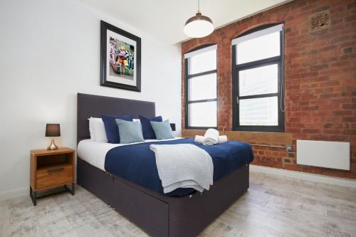 1 dormitorio con cama y pared de ladrillo en Sleek New York style Apartment in Central Leeds, en Leeds