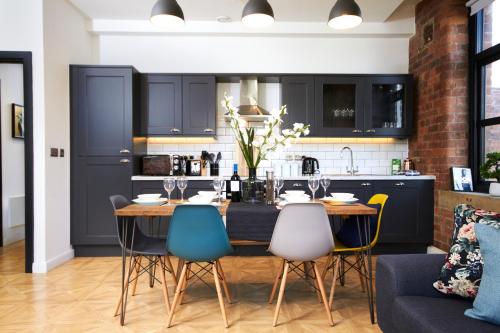 uma cozinha com uma mesa de jantar e cadeiras em Sleek New York style Apartment in Central Leeds em Leeds