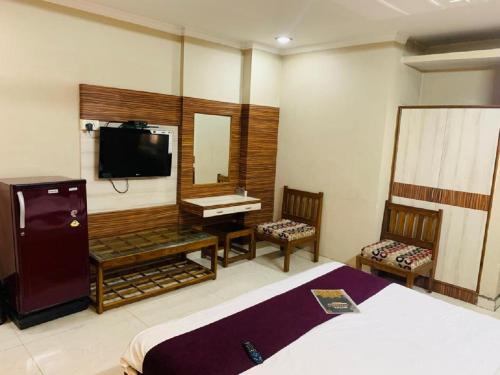 una camera con letto, specchio e TV di HOTEL ANAND a Jhansi