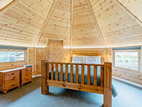 a log cabin with a bed and two windows at 1 Bed in Biggar 91252 in Libberton