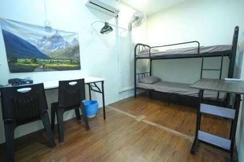 a room with bunk beds and a desk and a table at Aimelia guest house by G traveler in Petaling Jaya