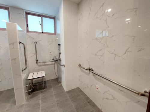 baño con paredes de mármol blanco y ducha a ras de suelo en 安平商旅Choona Hotel Anping en Anping
