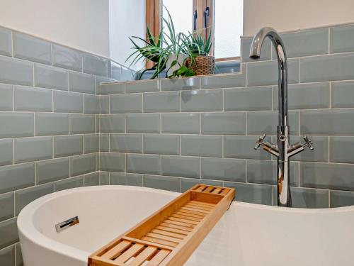 een badkamer met een bad met een kraan bij 2 Bed in Cheddar 91358 in Loxton