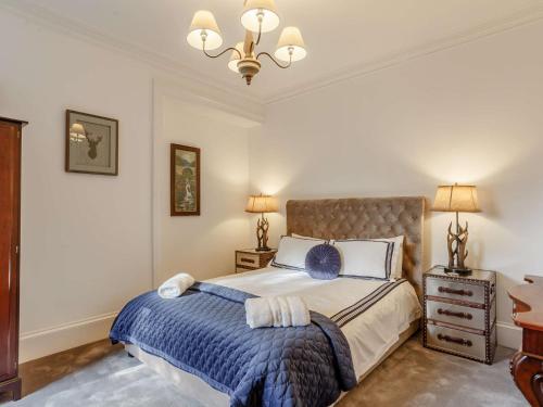 a bedroom with a bed and a chandelier at 4 Bed in Wick 91390 in Wick