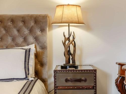 a lamp on a night stand next to a bed at 4 Bed in Wick 91390 in Wick