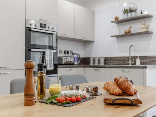 a kitchen with a table with bread and vegetables on it at 4 Bed in Wick 91390 in Wick