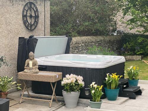 a bath tub with a buddha sitting on a table at 4 Bed in Wick 91390 in Wick