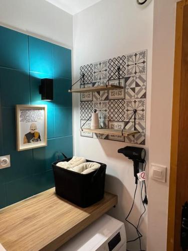 - une salle de bains avec des murs bleus et une étagère avec des serviettes dans l'établissement O' Chênes Rouges GERARDMER - 4-6 pers avec terrasse vue lac et montagne, à Gérardmer