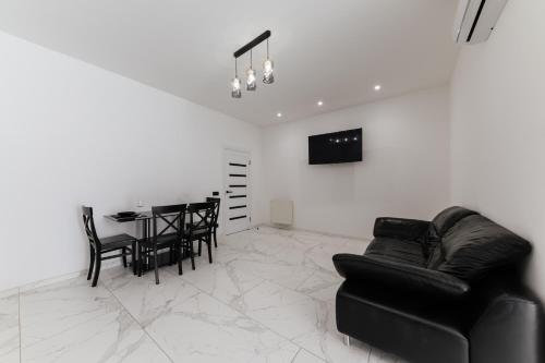 a living room with a black couch and a table at Luxury Apartments-Belochka in Uzhhorod