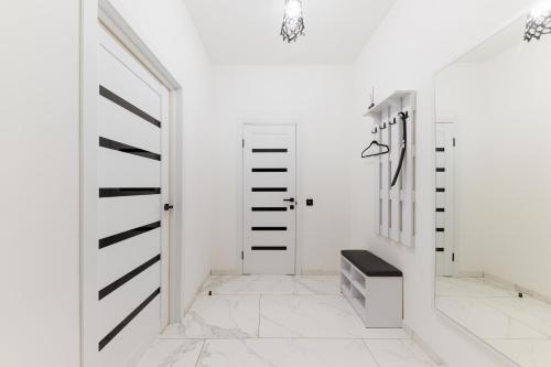 a hallway with white walls and white floors and a staircase at Luxury Apartments-Belochka in Uzhhorod
